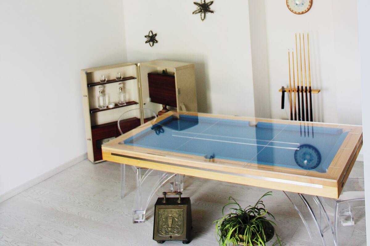 Une pièce avec une table de ping-pong, une horloge et une plante.
