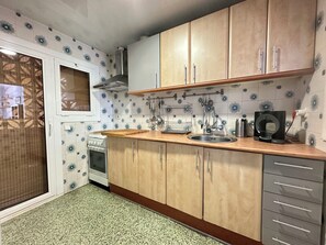 A kitchen with wooden cabinets, a stainless steel sink, and a built-in oven.