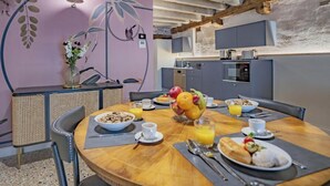 Une table en bois, des chaises et un panier de fruits : voilà une belle présentation pour le petit-déjeuner.