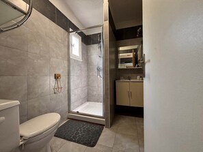 Ein modernes Badezimmer mit Toilette, Dusche und Waschbecken.