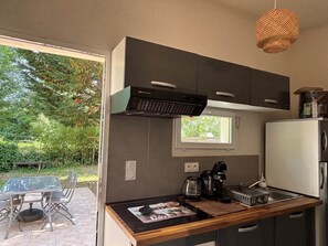 Eine moderne Küche mit Einbauherd, Kaffeemaschine und Kühlschrank.