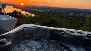 A hot tub with a view of a sunset over a lake and surrounding landscape. - Roundtop Mansion Breathtaking View indoor Pool (Wrightsville)