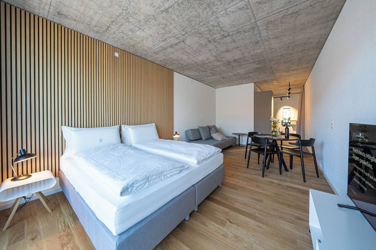 Un dormitorio moderno con una cama grande, un escritorio y un sofá.