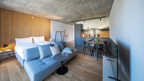 Una sala moderna con un sofá, una mesita redonda y un televisor.