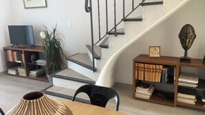 A staircase with a modern design, surrounded by bookshelves and a television. - 2 ROOM APARTMENT, SEMAPHORE, SAINTE MAXIME (Sainte-Maxime)