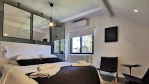 A modern bedroom with a large bed, a chair, a small table, and a large window. - 4 Bedroom Villa in Anglet (Anglet)