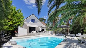 A swimming pool with lounge chairs and a house in the background. - 4 Bedroom Villa in Anglet (Anglet)