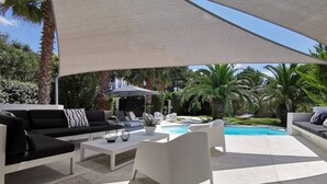 A modern outdoor patio with a pool, white furniture, and a large canopy. - 4 Bedroom Villa in Anglet (Anglet)