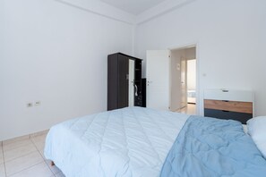 Une chambre à coucher avec un lit, une armoire et une table de chevet.