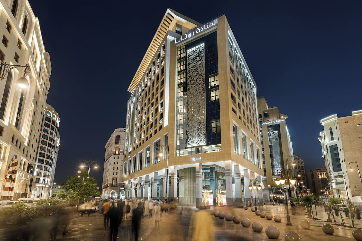 A modern hotel with a prominent vertical facade, multiple floors, and a large entrance.