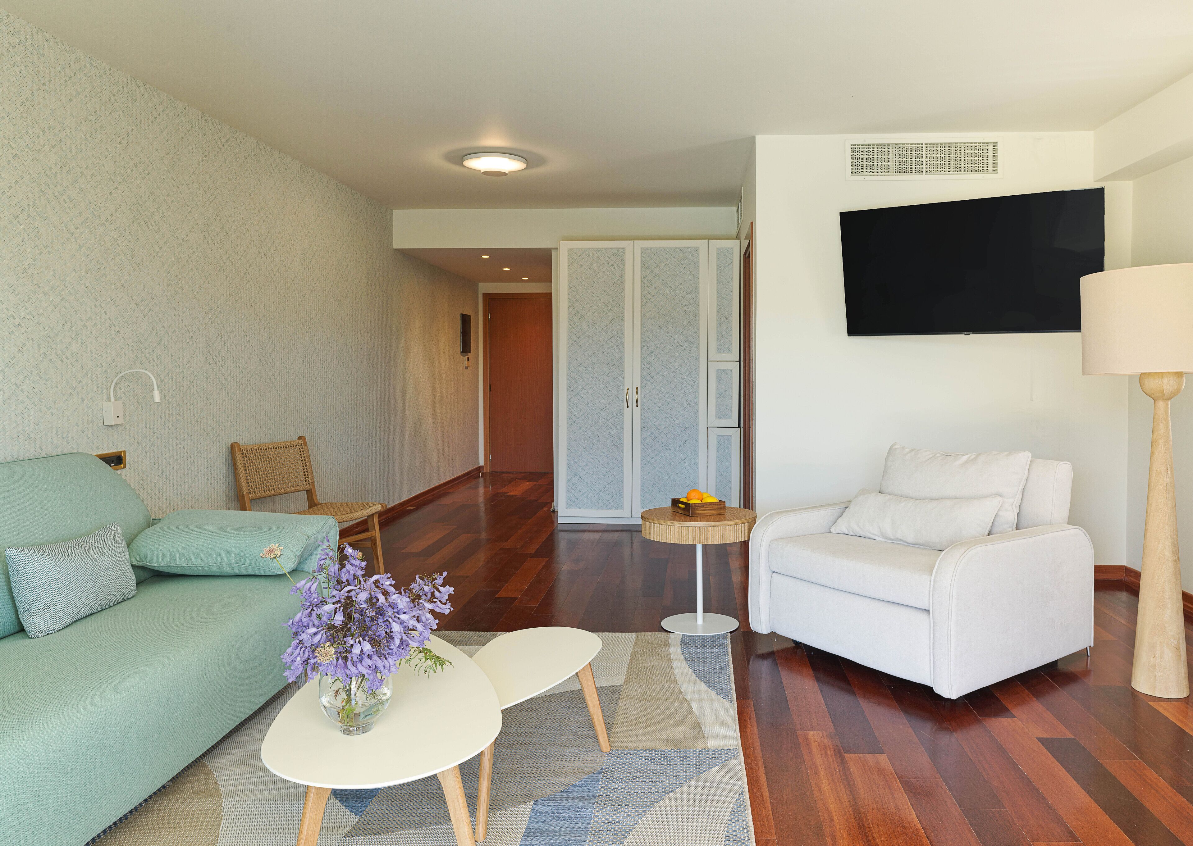 Una sala de estar moderna con un sofá, un sillón, una mesita de centro y una lámpara.
