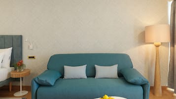 Ein smaragdgrünes Sofa mit gemusterten Kissen, ein kleiner Holztisch mit einer Blumenvase und ein weißer Couchtisch mit Obstschale.