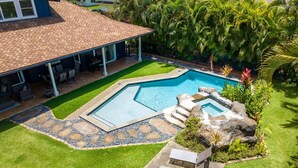 A swimming pool with a hot tub, surrounded by a well-maintained lawn and tropical plants. - NEW LISTING - Nani Hale, 4 bed, AC, pool & jacuzzi (Koloa)