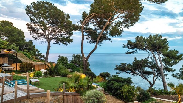 Una proprietà vista mare con piscina e area relax all'aperto.