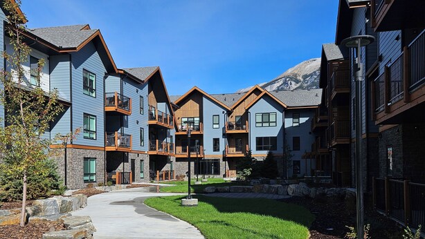 Un immeuble moderne à plusieurs étages, doté de balcons et d’une cour intérieure.