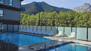 Une piscine avec des chaises longues et une vue sur les montagnes en arrière-plan.