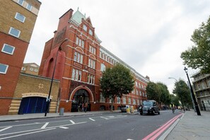 A red brick building with a large arched entrance and multiple windows.