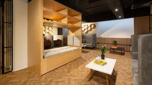 A modern living room with a built-in sofa, a coffee table, and a bookshelf. - Great Dover Street Apartments, King’s College London (London)