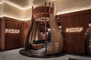 A modern lobby with a unique spiral staircase, wooden paneling, and a reception desk.