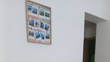 Un piccolo mobiletto in legno bianco con ripiano superiore in legno, un libro e una scatola di riviste.