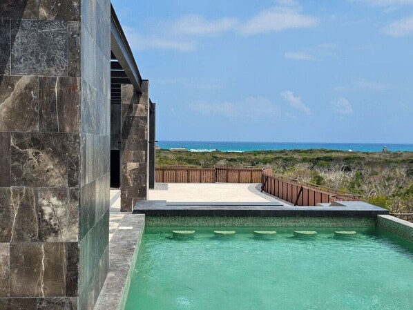Relax by the pool, surrounded by a deck and ocean views.
