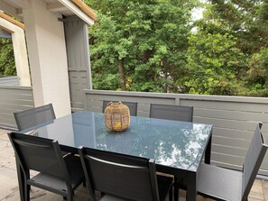 Relax in style with a glass-top table and comfortable seating surrounded by lush greenery.