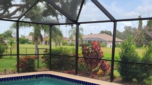Una piscina cubierta con vistas a una zona residencial y vegetación.