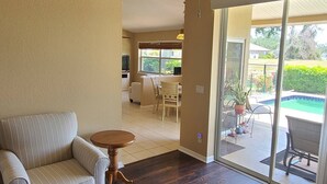 Un salón espacioso con ventilador de techo, una mesa de centro de madera y un sofá.