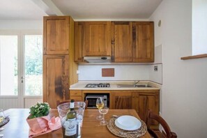 A kitchen with wooden cabinets, a gas stove, and a sink.