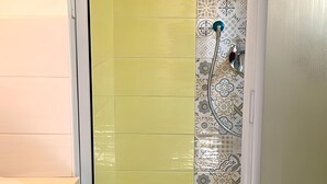 A bathroom with a shower enclosure, a toilet, and a sink. - In the Hospital Zone of Naples. (Napoli)