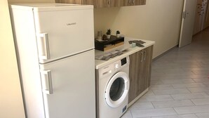 A compact kitchen with a built-in washing machine and a refrigerator. - In the Hospital Zone of Naples. (Napoli)