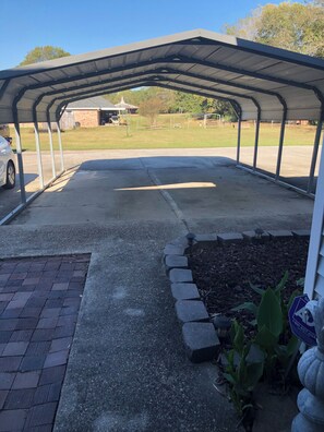 Un espace extérieur abrité, doté d’un sol pavé, d’un chemin en briques et d’un parterre agrémenté de plantes.