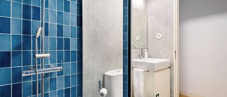 A bathroom with a shower, toilet, and sink.
