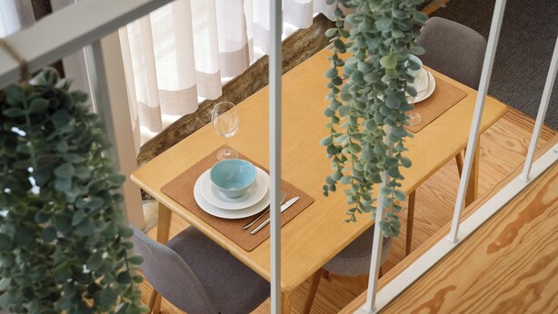 A dining area with a wooden table, grey chairs, and a hanging plant. - Sbucks - Trendy Space in Porto - Next to Ribeira (Porto)
