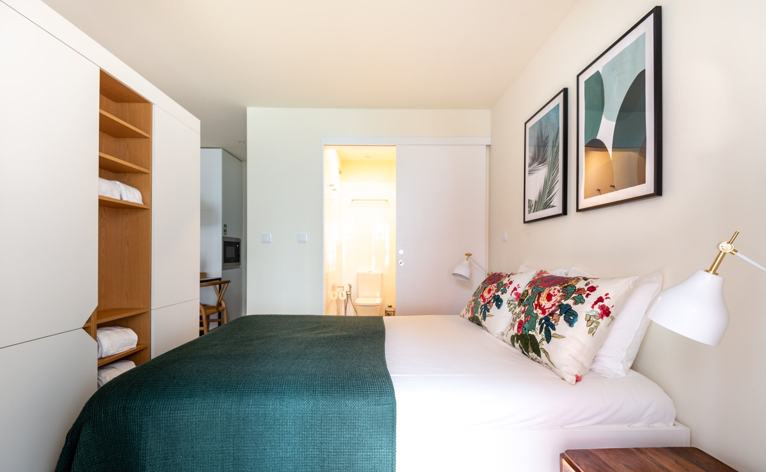 Ein Schlafzimmer mit Bett, Kleiderschrank, Nachttisch und Beistelltisch.