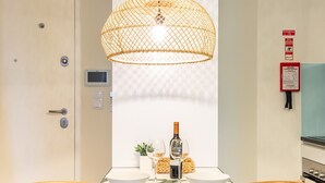 A dining area with a table set for two, a bottle of wine, and a small plant. - Foz003 · Light-filled Studio With Courtyard Garden (Porto)