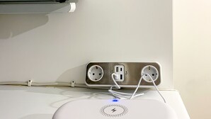 Ein weißer LG-Monitor an der Wand befestigt, mit einer Steckschienenleiste darunter.