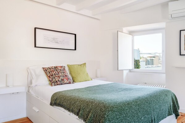 A bedroom with a bed, a window, a radiator, and a framed picture on the wall. - Flora3 Flora Apartments, Studio w/ Garden View (Porto)