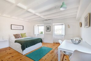 A modern bedroom with a bed, a desk, and a window. - Flora3 Flora Apartments, Studio w/ Garden View (Porto)