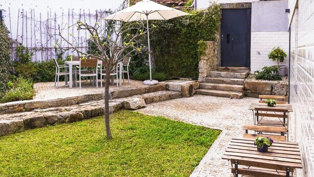 A patio area with a table and chairs, a small tree, and a bench with potted plants. - Flora3 Flora Apartments, Studio w/ Garden View (Porto)