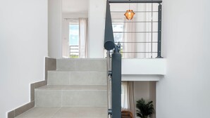 Un escalier avec une rampe, menant à un niveau supérieur.