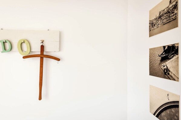 A wall with a wooden cross and letters 'D' and 'O' hanging on a whiteboard. - Aguda1 · Aguda's Family House 4bd, Parking, BBQ (Porto)