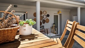 Une table en bois, sur laquelle se trouvent un pot de fleurs et un panier en osier.