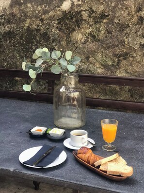 A breakfast setup on an outdoor table with a glass jar, a cup of coffee, a glass of orange juice, a croissant, and a plate of toast. - Acm031 Gallery 92 2BD Duplex +balcony (Porto)