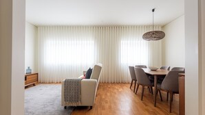 A modern living room with a sofa, dining table, and chairs. - Acm031 Gallery 92 2BD Duplex +balcony (Porto)