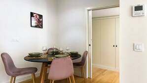 A dining area with a round table, four chairs, and a pendant light. - Prt002 · Charming 1 bed +1 @ Avenida dos Aliados (Porto)