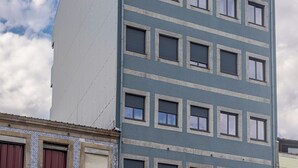 A multi-story building with a modern architectural style, featuring a combination of rectangular and square windows, and a flat roof.