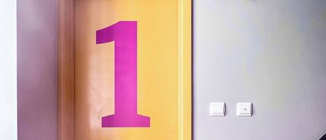 Une porte avec une grande plaque portant l’inscription « 1b », une poignée en métal et un trou de serrure.