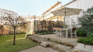 A patio area with a table and chairs, a stone pathway, and a hedge. - Flora4 Flora Apartments, Studio on 2nd Floor (Porto)