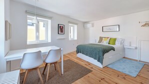 A bedroom with a bed, a desk, two chairs, and a window. - Flora4 Flora Apartments, Studio on 2nd Floor (Porto)